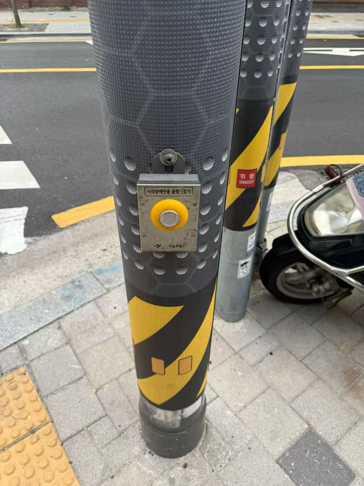 A roadside accessibility audio-guide button in Seoul